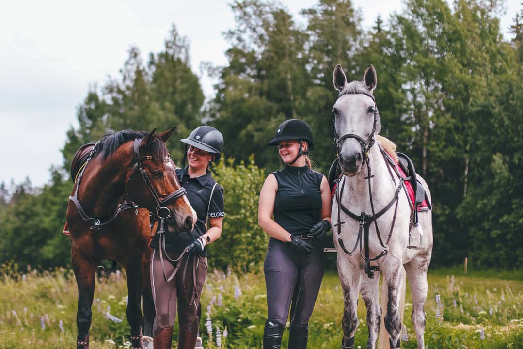 Kuvassa ratsastajat hevosten kanssa